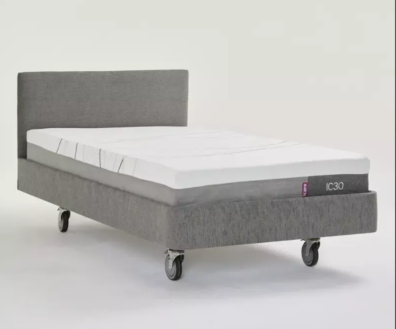 A gray upholstered bed frame with a white mattress, shown on a clean light gray studio background. The bed frame has a tall rectangular headboard and is fitted with caster wheels.